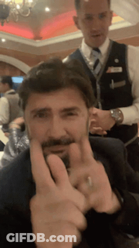 A Man With A Beard Is Making A Peace Sign With His Fingers GIF