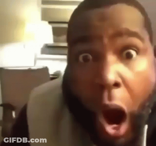 A Man With A Beard Is Making A Surprised Face With His Mouth Open . GIF
