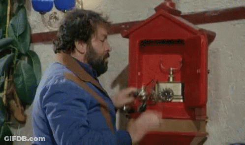 A Man With A Beard Is Opening A Red Mailbox With A Screwdriver . GIF