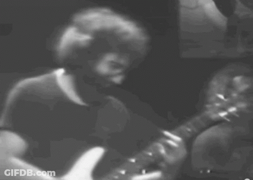 A Man With A Beard Is Playing A Guitar GIF