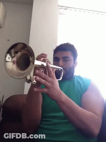 A Man With A Beard Is Playing A Trumpet GIF