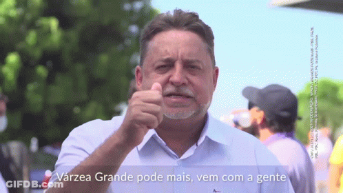 A Man With A Beard Is Pointing At The Camera With The Words Varzea Grande Pode Mais Vem Com A Gente Below Him GIF