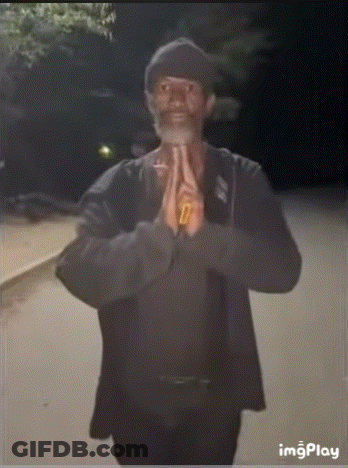 A Man With A Beard Is Praying With His Hands Folded In Front Of His Face GIF