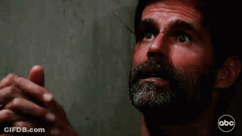 A Man With A Beard Is Praying With His Hands Folded In Prayer . GIF
