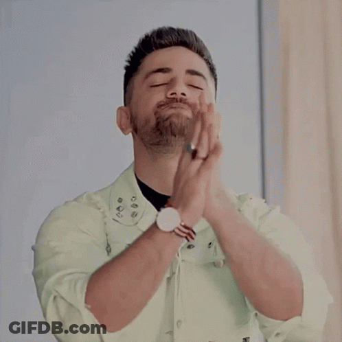 A Man With A Beard Is Praying With His Hands Together GIF