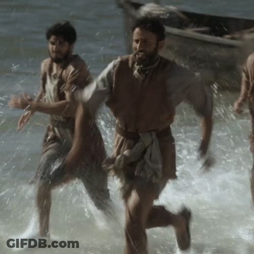 A Man With A Beard Is Running Through The Water GIF