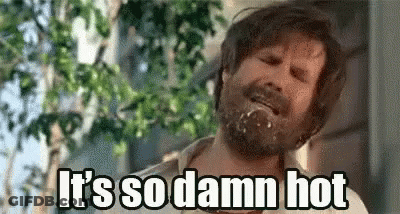 A Man With A Beard Is Saying `` It 'S So Damn Hot '' While Eating A Donut . GIF