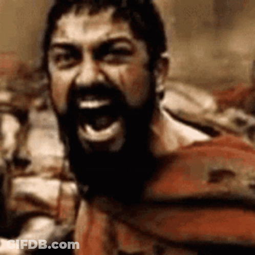 A Man With A Beard Is Screaming With His Mouth Open In A Close Up . GIF