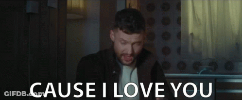 A Man With A Beard Is Singing In A Dark Room And The Words `` Cause I Love You '' Are Behind Him . GIF