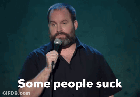 A Man With A Beard Is Singing Into A Microphone With The Words " Some People Suck " Below Him GIF