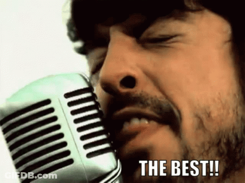 A Man With A Beard Is Singing Into A Microphone With The Words " The Best " Written Below Him GIF