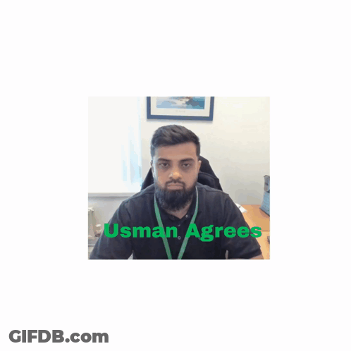 A Man With A Beard Is Sitting At A Desk With Usman Agrees Written On The Bottom GIF