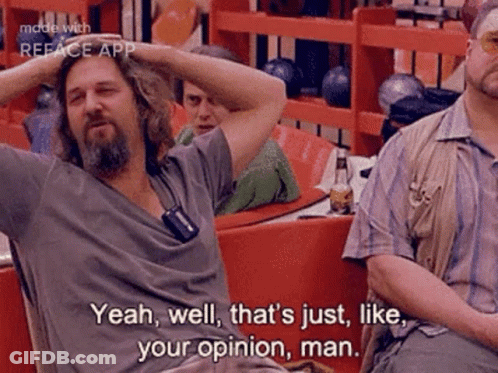 A Man With A Beard Is Sitting At A Table In A Bowling Alley With His Hands On His Head . GIF