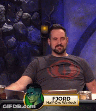 A Man With A Beard Is Sitting At A Table With A Name Tag That Says Fjord Half-Orc Warlock GIF