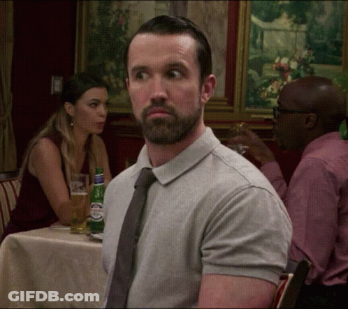 A Man With A Beard Is Sitting At A Table With A Woman GIF