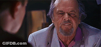 A Man With A Beard Is Sitting At A Table With Another Man . GIF