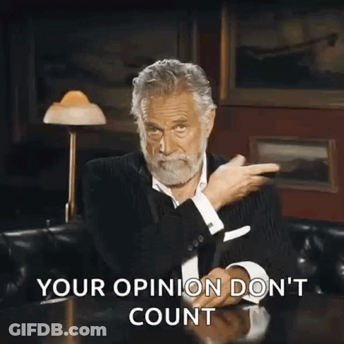 A Man With A Beard Is Sitting At A Table With His Hands In The Air And The Words Your Opinion Do N't Count GIF