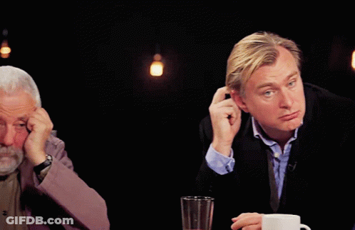 A Man With A Beard Is Sitting At A Table With His Head In His Hands GIF