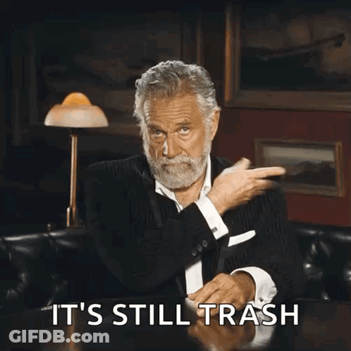 A Man With A Beard Is Sitting At A Table With The Words It 'S Still Trash Written On It GIF