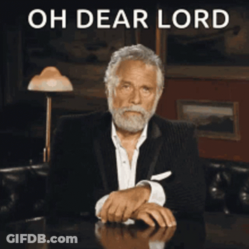 A Man With A Beard Is Sitting At A Table With The Words Oh Dear Lord Behind Him GIF