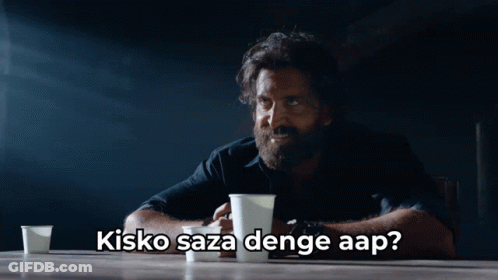 A Man With A Beard Is Sitting At A Table With Two Cups Of Coffee And The Caption Kisko Saza Denge Aap GIF