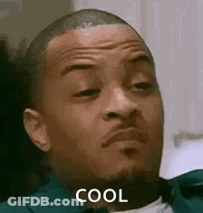 A Man With A Beard Is Sitting Down And Making A Funny Face . GIF