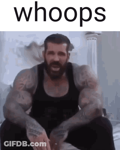 A Man With A Beard Is Sitting Down With The Words Whoops Above Him GIF