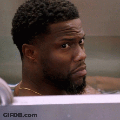 A Man With A Beard Is Sitting In A Bathtub Looking At The Camera GIF