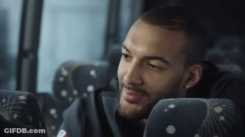 A Man With A Beard Is Sitting In A Bus Seat GIF