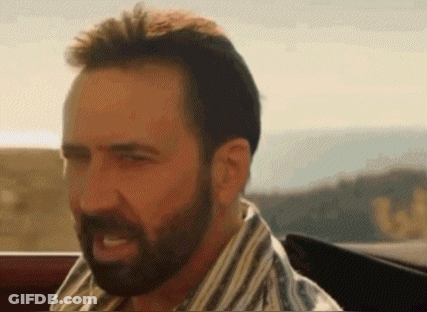 A Man With A Beard Is Sitting In A Car And Making A Face . GIF