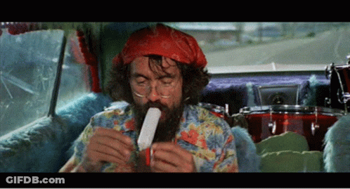 A Man With A Beard Is Sitting In A Car Eating A Popsicle GIF