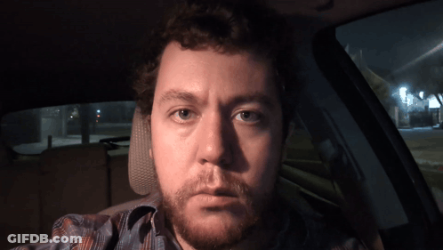 A Man With A Beard Is Sitting In A Car With His Eyes Closed GIF