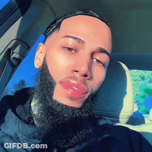 A Man With A Beard Is Sitting In A Car With His Eyes Closed GIF
