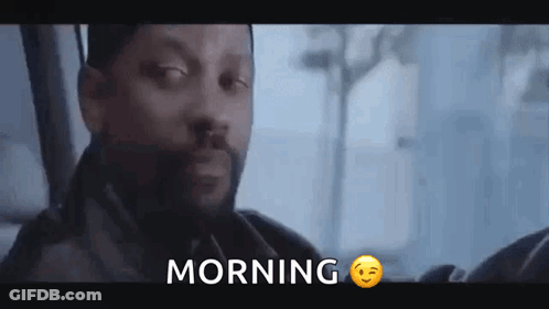 A Man With A Beard Is Sitting In A Car With The Word Morning Written Above Him . GIF