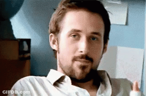 A Man With A Beard Is Sitting In A Chair And Making A Face . GIF