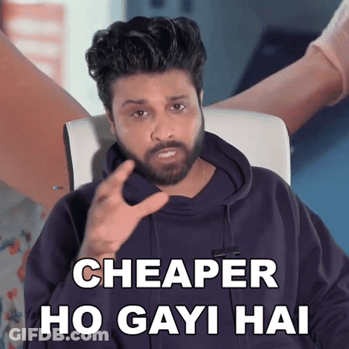 A Man With A Beard Is Sitting In A Chair And Says " Cheaper Ho Gayi Hai " GIF