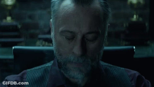 A Man With A Beard Is Sitting In A Chair With Smoke Coming Out Of His Mouth . GIF