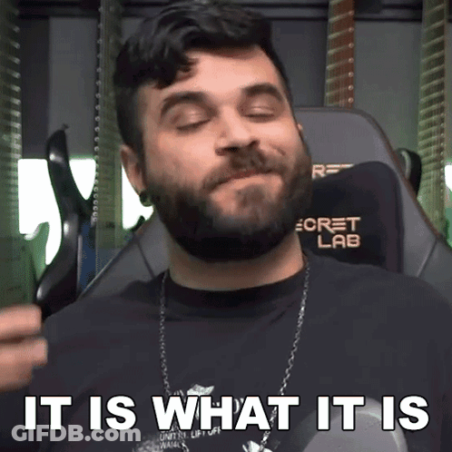 A Man With A Beard Is Sitting In A Chair With The Words " It Is What It Is " Above Him GIF