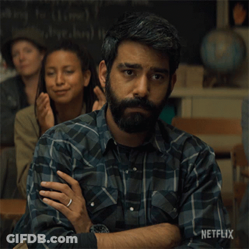 A Man With A Beard Is Sitting In A Classroom With Netflix Written On The Bottom Of The Image GIF