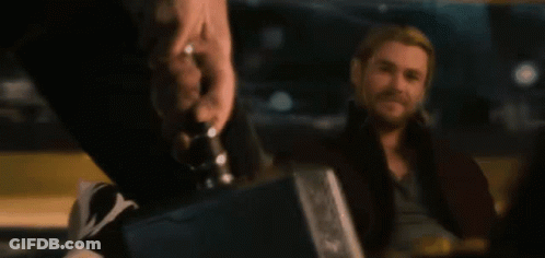 A Man With A Beard Is Sitting In A Dark Room GIF