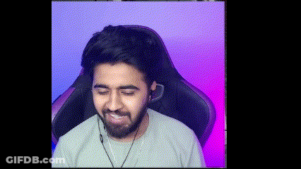 A Man With A Beard Is Sitting In A Gaming Chair With Headphones On . GIF