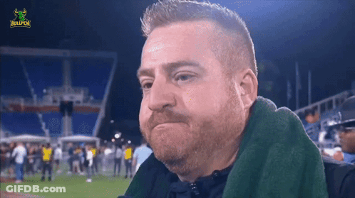 A Man With A Beard Is Sitting In A Stadium With A Bullpen Logo GIF