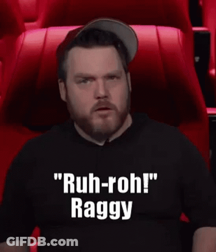 A Man With A Beard Is Sitting In A Theater Watching A Movie And Making A Funny Face . GIF