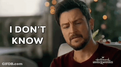 A Man With A Beard Is Sitting In Front Of A Christmas Tree And Saying `` I Don 'T Know '' . GIF