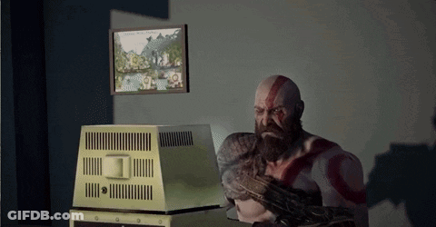 A Man With A Beard Is Sitting In Front Of A Computer Monitor GIF