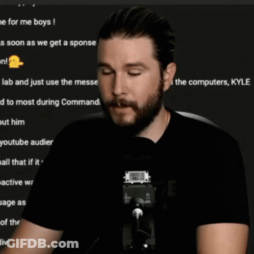 A Man With A Beard Is Sitting In Front Of A Microphone And The Words Pfft Are On The Screen GIF