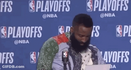 A Man With A Beard Is Sitting In Front Of A Microphone While Using A Laptop . GIF