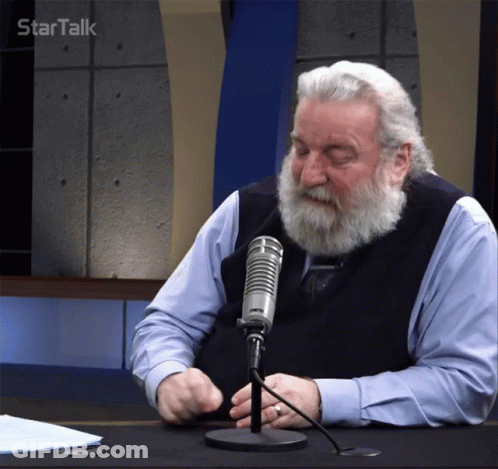 A Man With A Beard Is Sitting In Front Of A Microphone With Startalk Written On The Bottom Right GIF