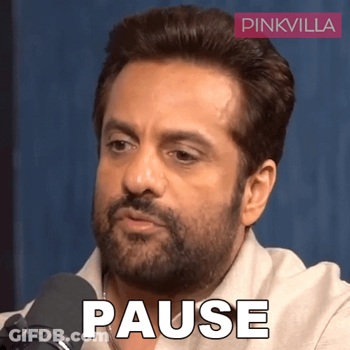 A Man With A Beard Is Sitting In Front Of A Microphone With The Word Pause Written On His Face GIF