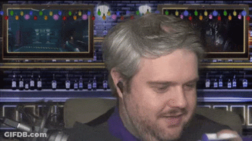 A Man With A Beard Is Sitting In Front Of A Screen That Says ' A ' On It GIF